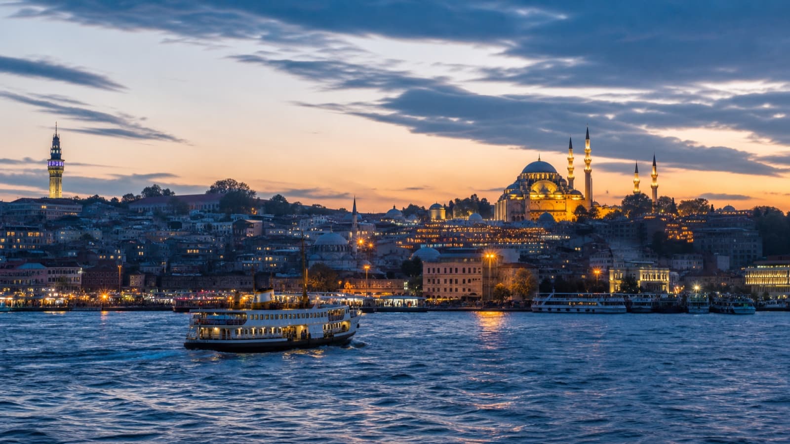 Istanbul, Turkey โ a ferry crossing the Bosphorus beneath domes and minarets at dusk
